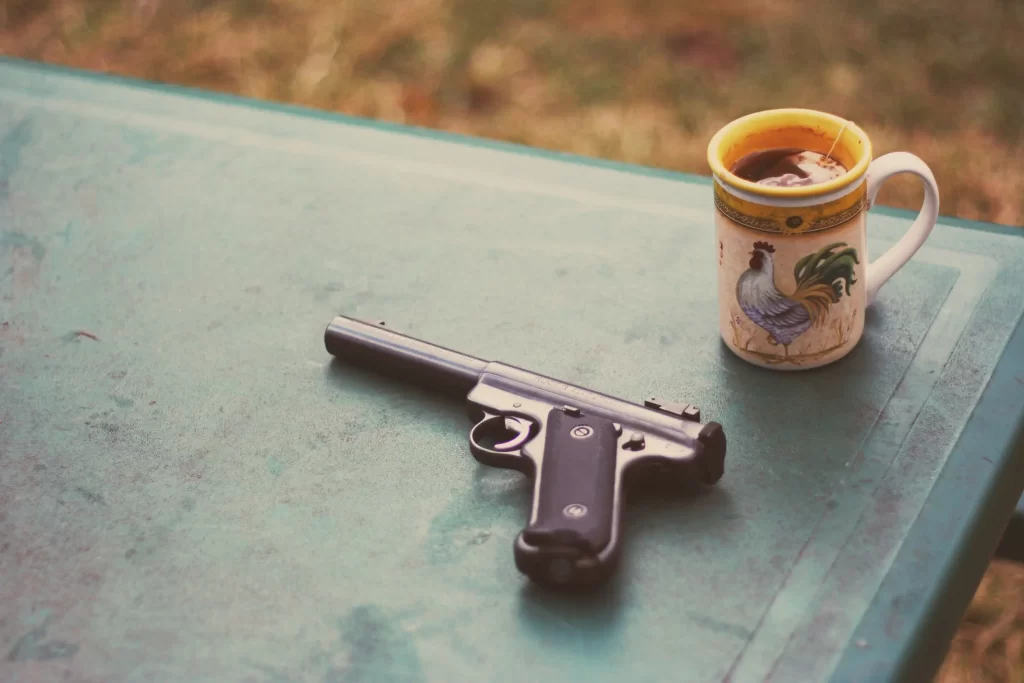 Can HOAs restrict guns? And other FAQs 1 gun on a table with a mug. HOA guns