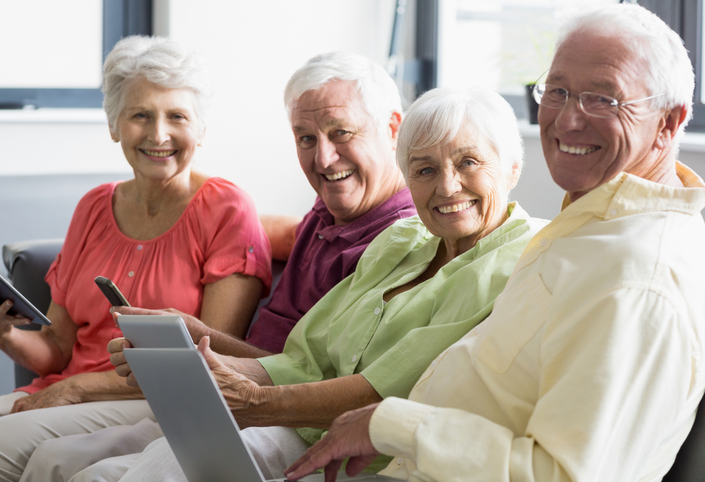 Why Invest in Self-Managed Condo Association Software? 1 Four board members delightedly using self-managed condo association software on mobile phones and laptop for efficient community management