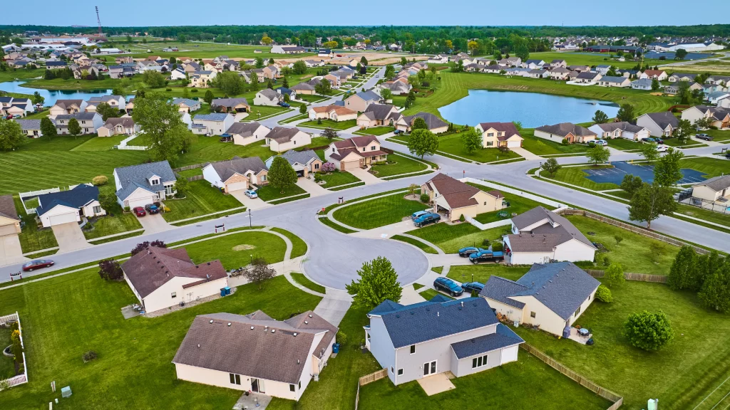 5 Benefits of HOAs: Learn The Amazing Upsides of Community Living 1 Image of an HOA with green area, swimming pool, cars, and lake. Common and natural areas are one of the benefits of HOAs